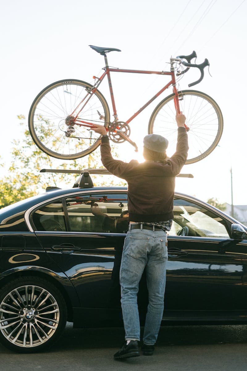 Man die fiets op zijn auto zet