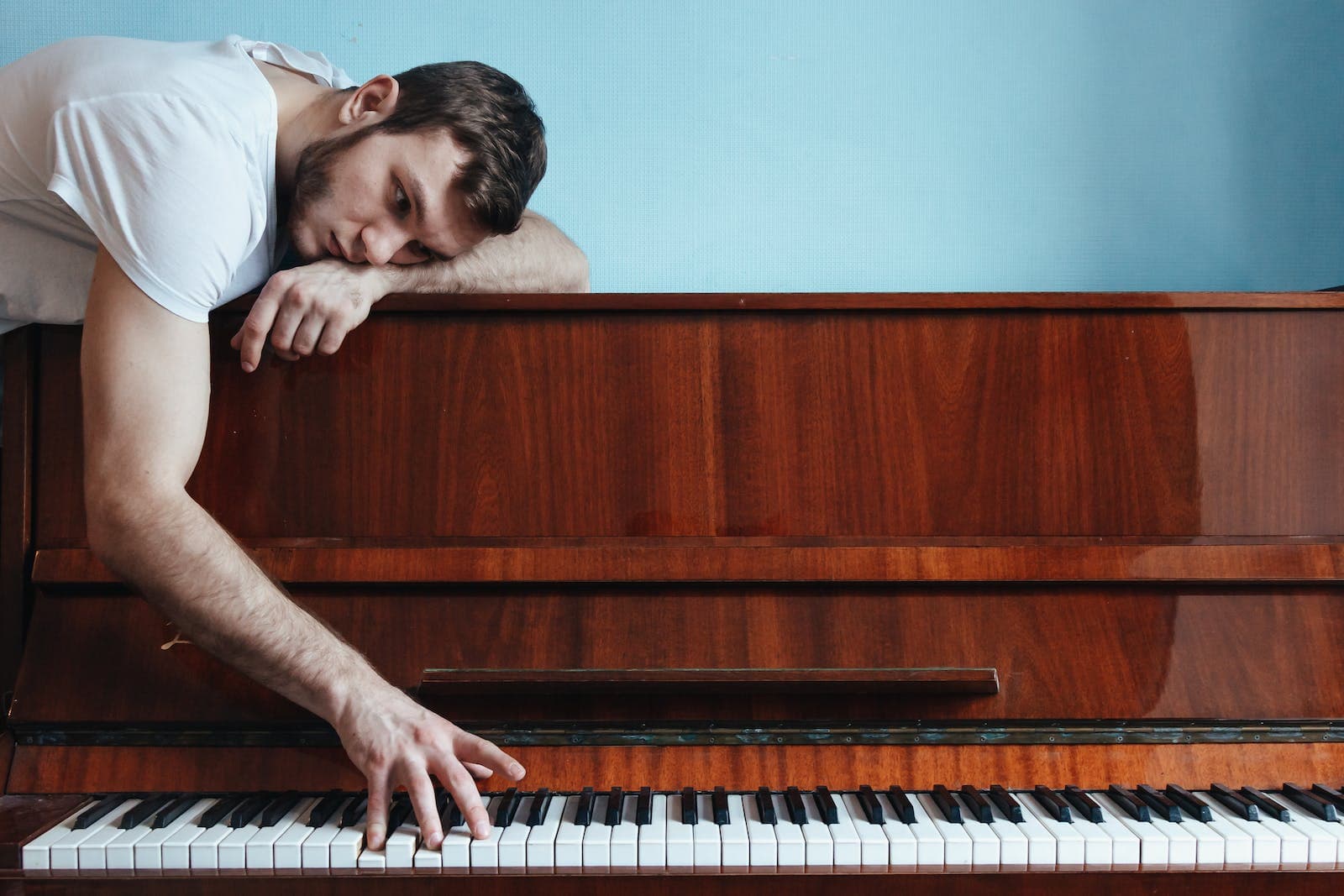 Man die de piano speelt vanaf de bovenkant van de piano