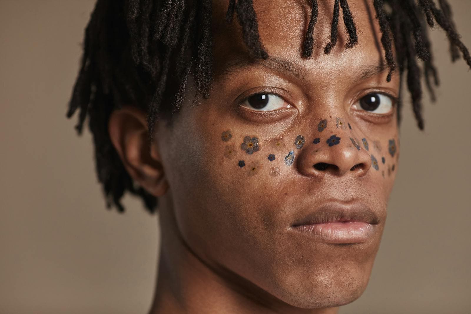 een man met tattoo's van bloemen op de wangen