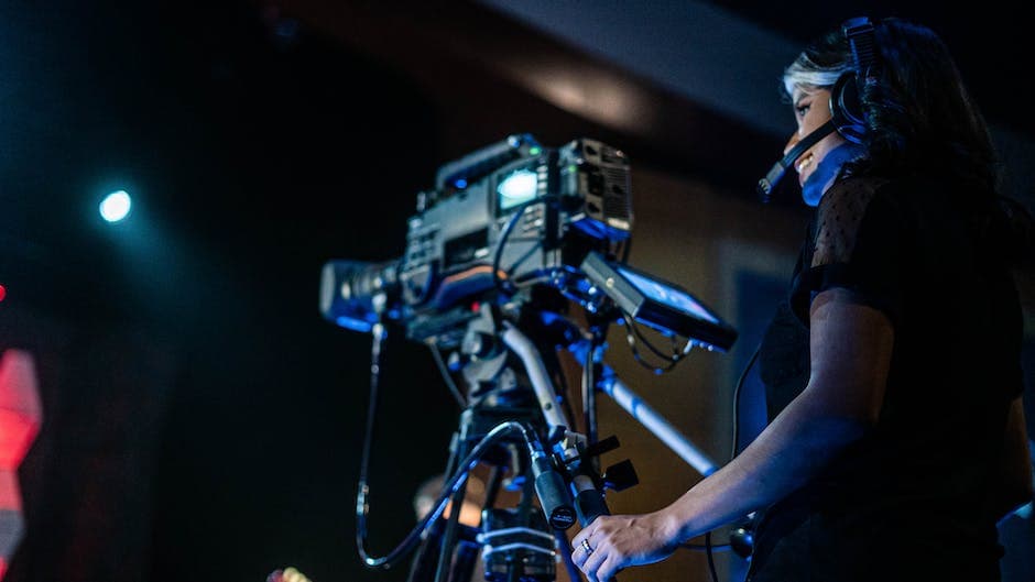 Vrolijke vrouwelijke videograaf die een evenement filmt