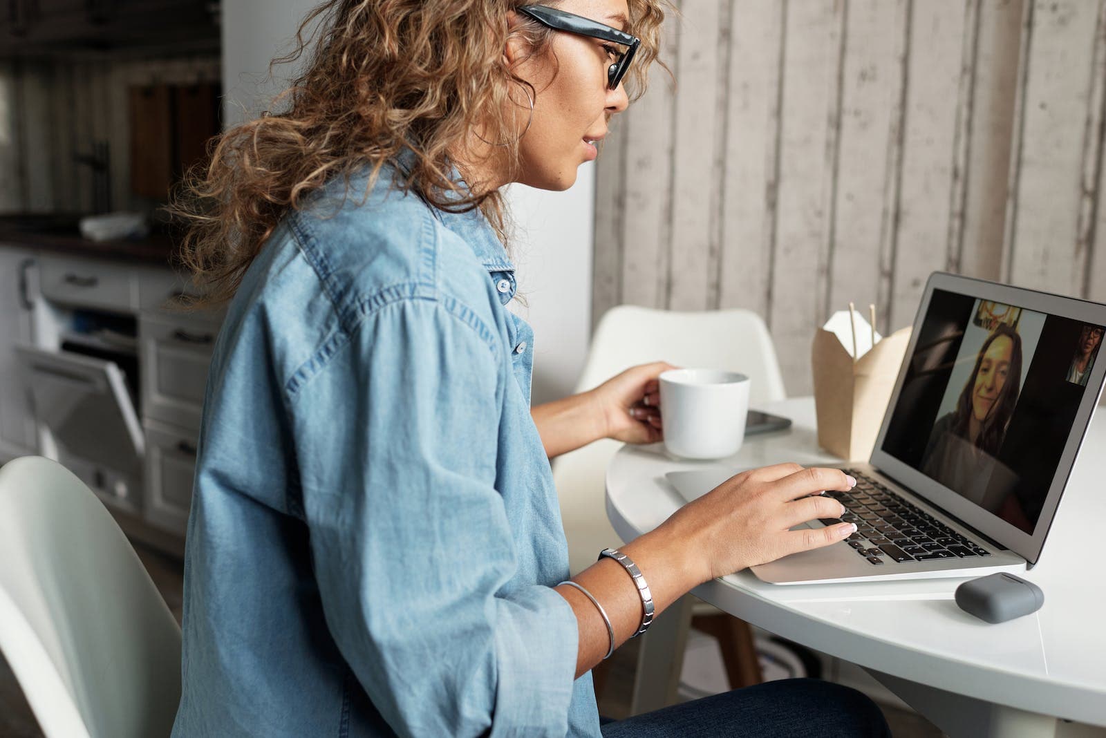 een vrouw zit achter een laptop te videobellen