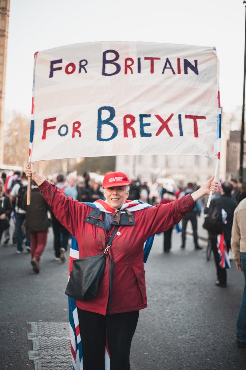 A Woman in Red Jacket Holding a Banner for britain, for brexit
