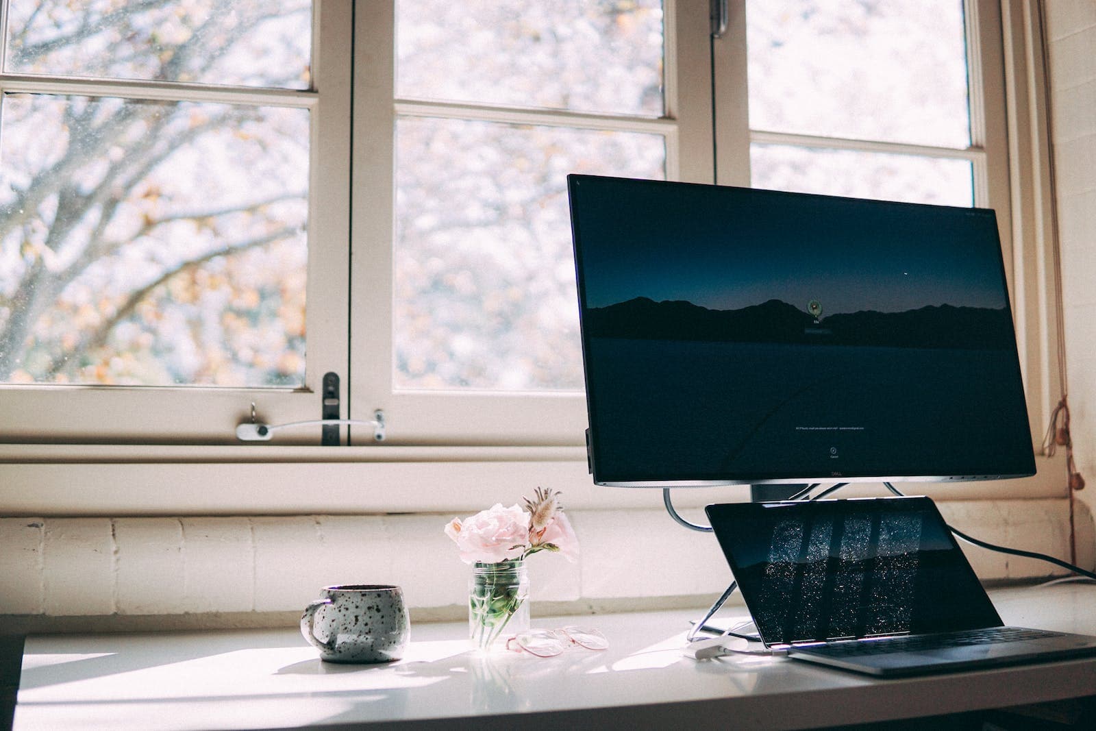 Een thuiswerkplek met laptop en scherm