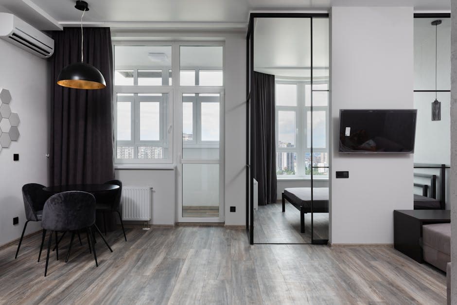 Hedendaagse kamerinterieur met stoelen onder lamp en airconditioning in licht huis met glazen wand