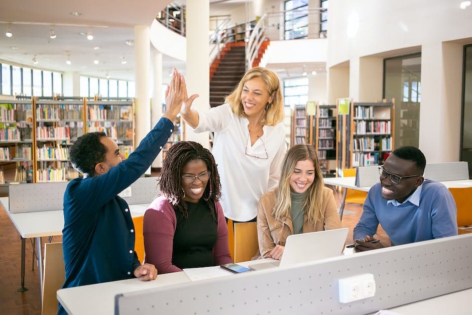 Vrolijke multiculturele studenten die high five geven aan de leraar