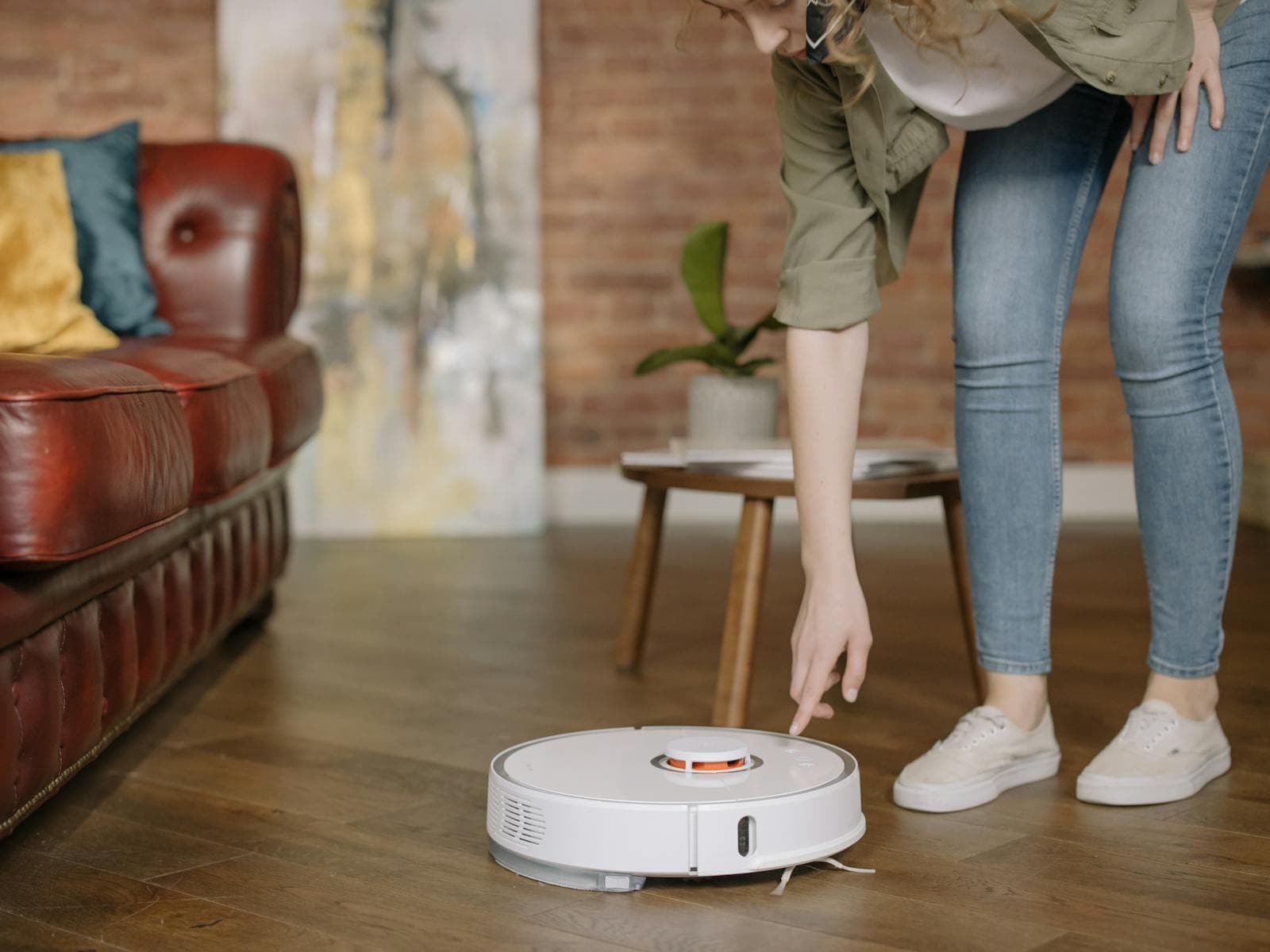 Vrouw die een robotstofzuiger bestuurt