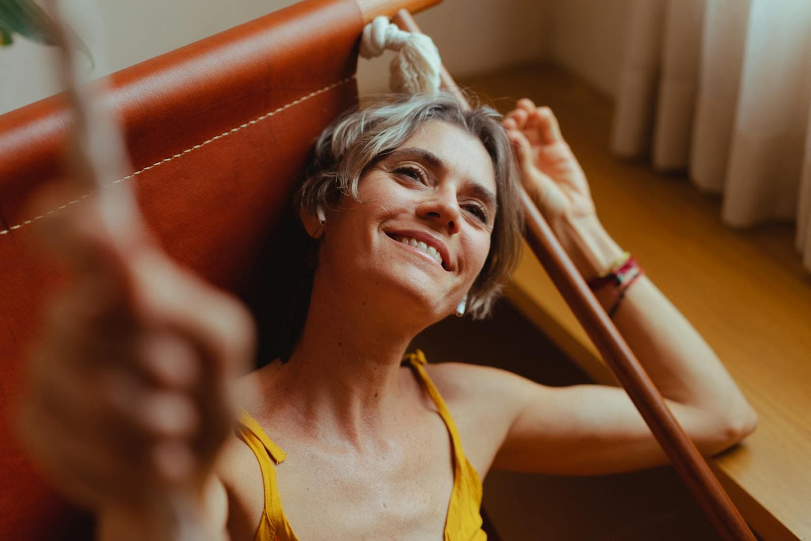 Een oudere vrouw die in hangmat relaxt luisterend naar selfcare poecast