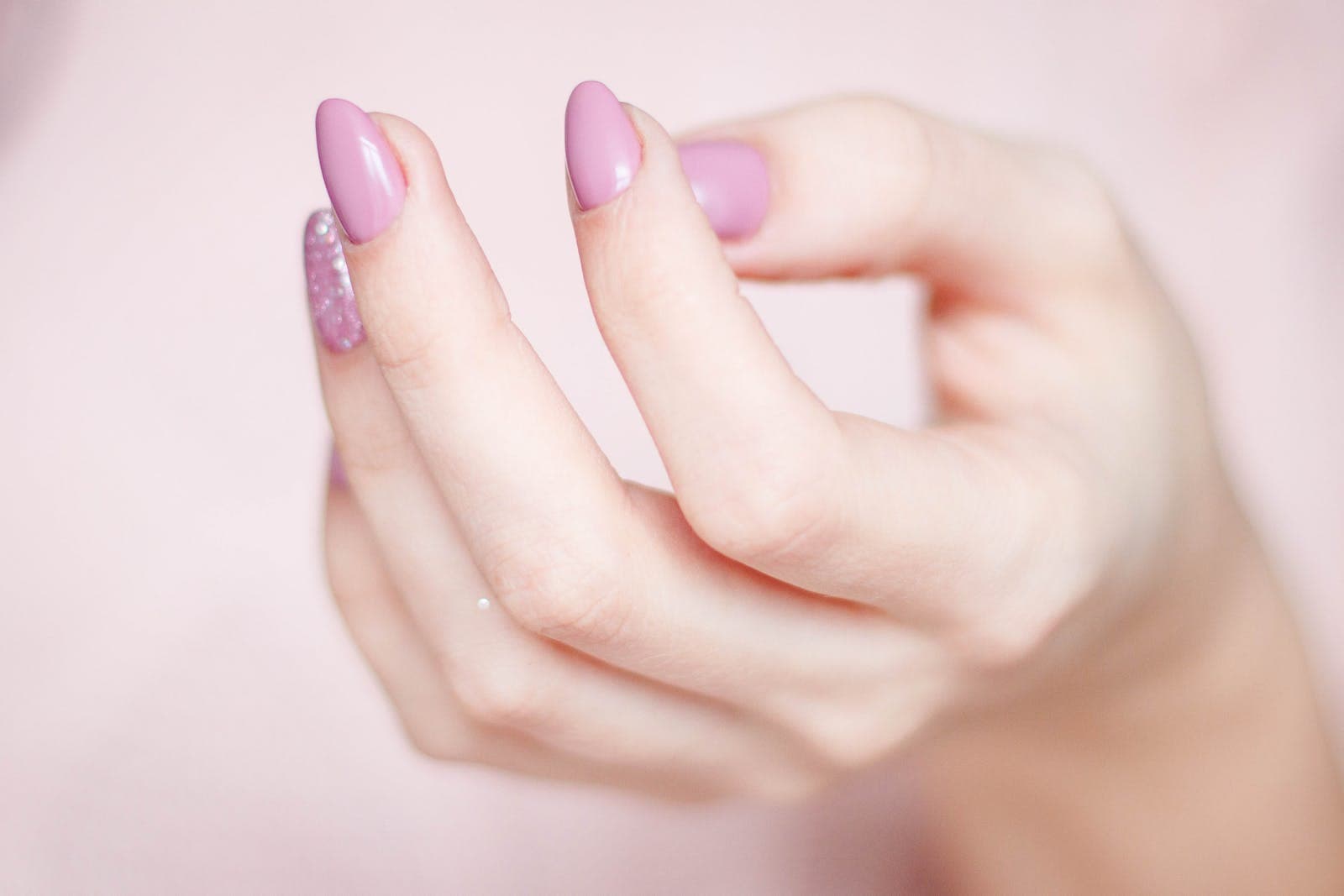 De hand van een persoon met gelnagellak op